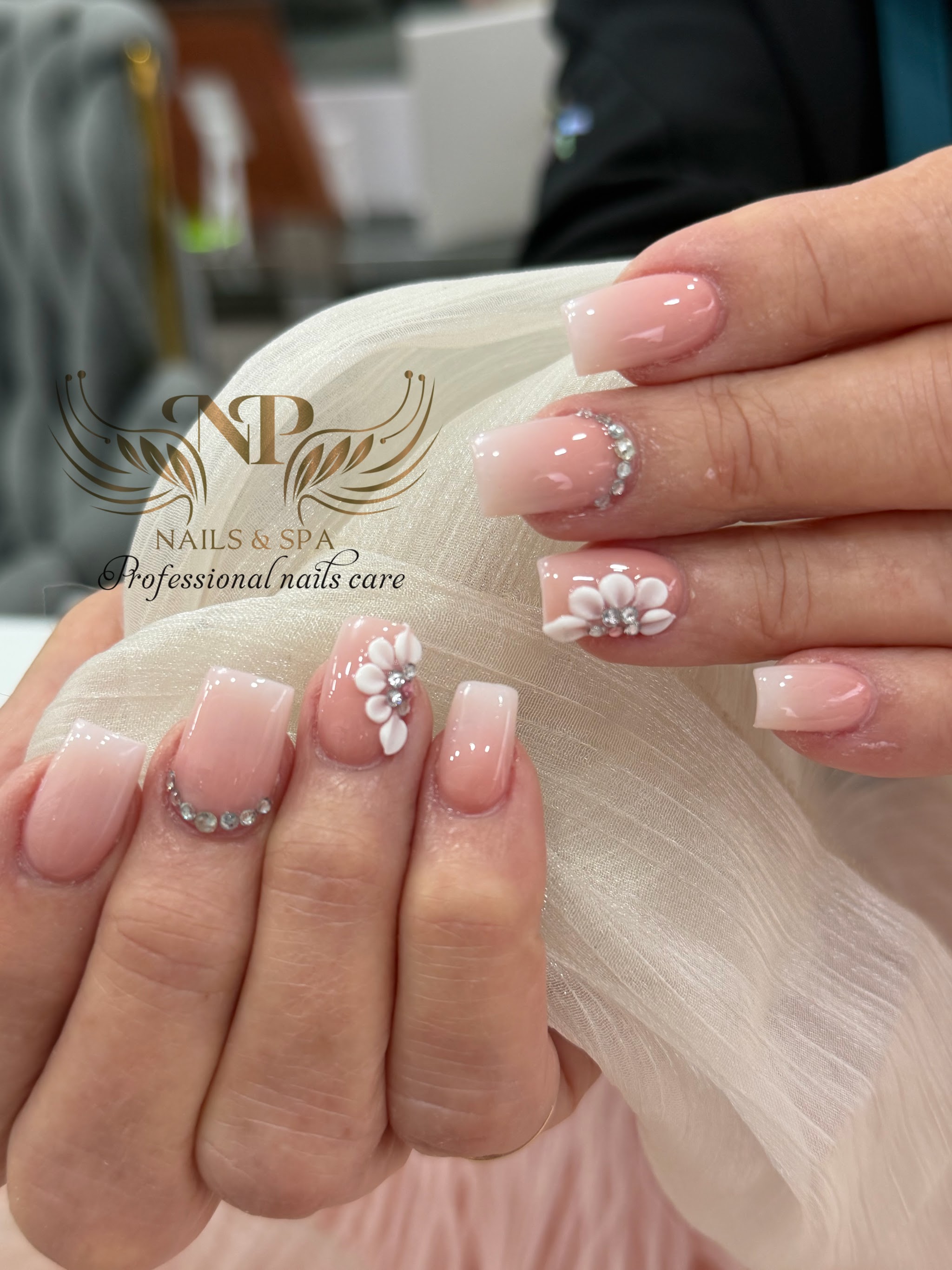 Nude French tips with 3D white flowers and gems