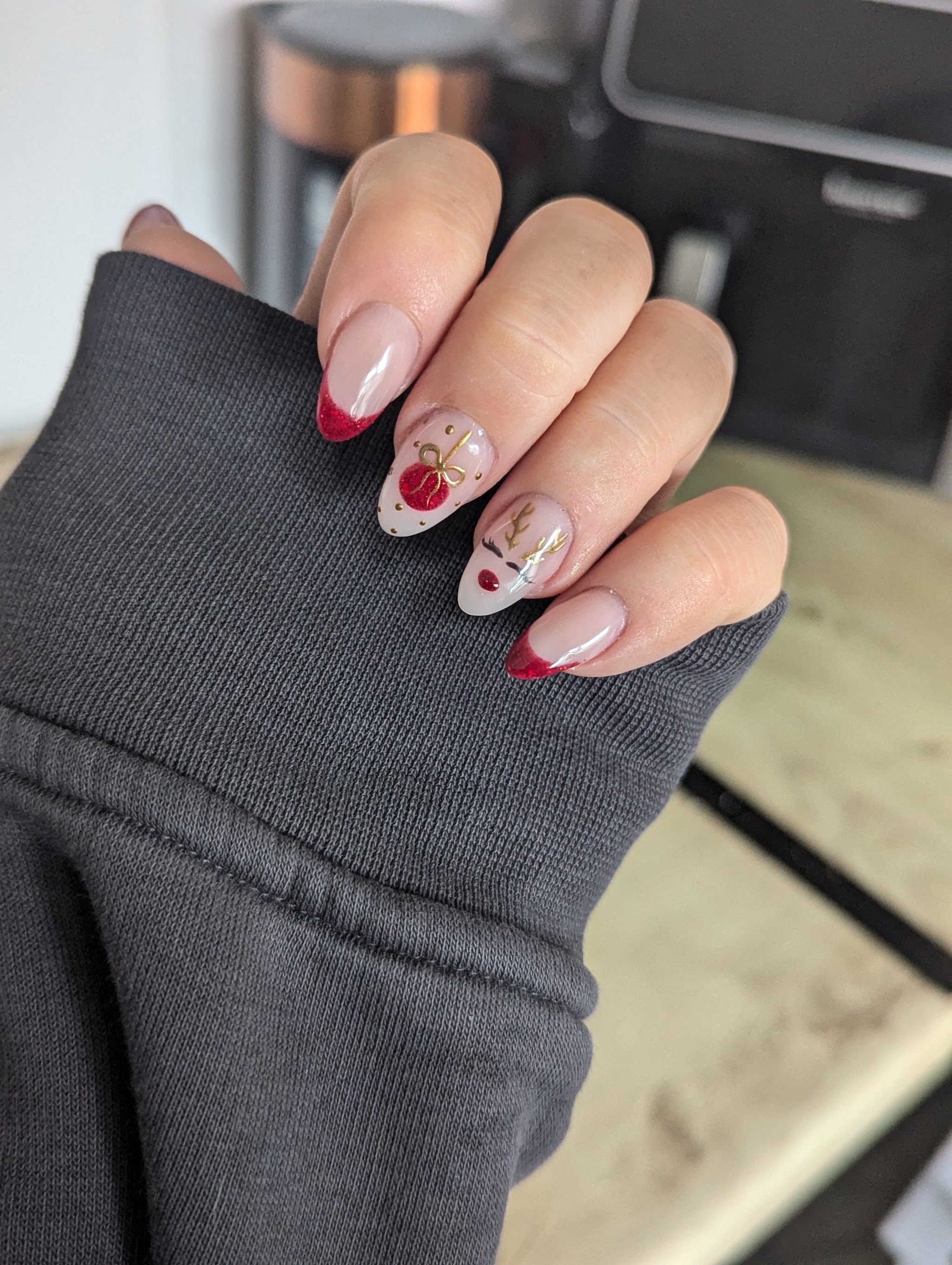 Nude almond nails with red French tips and cherry art