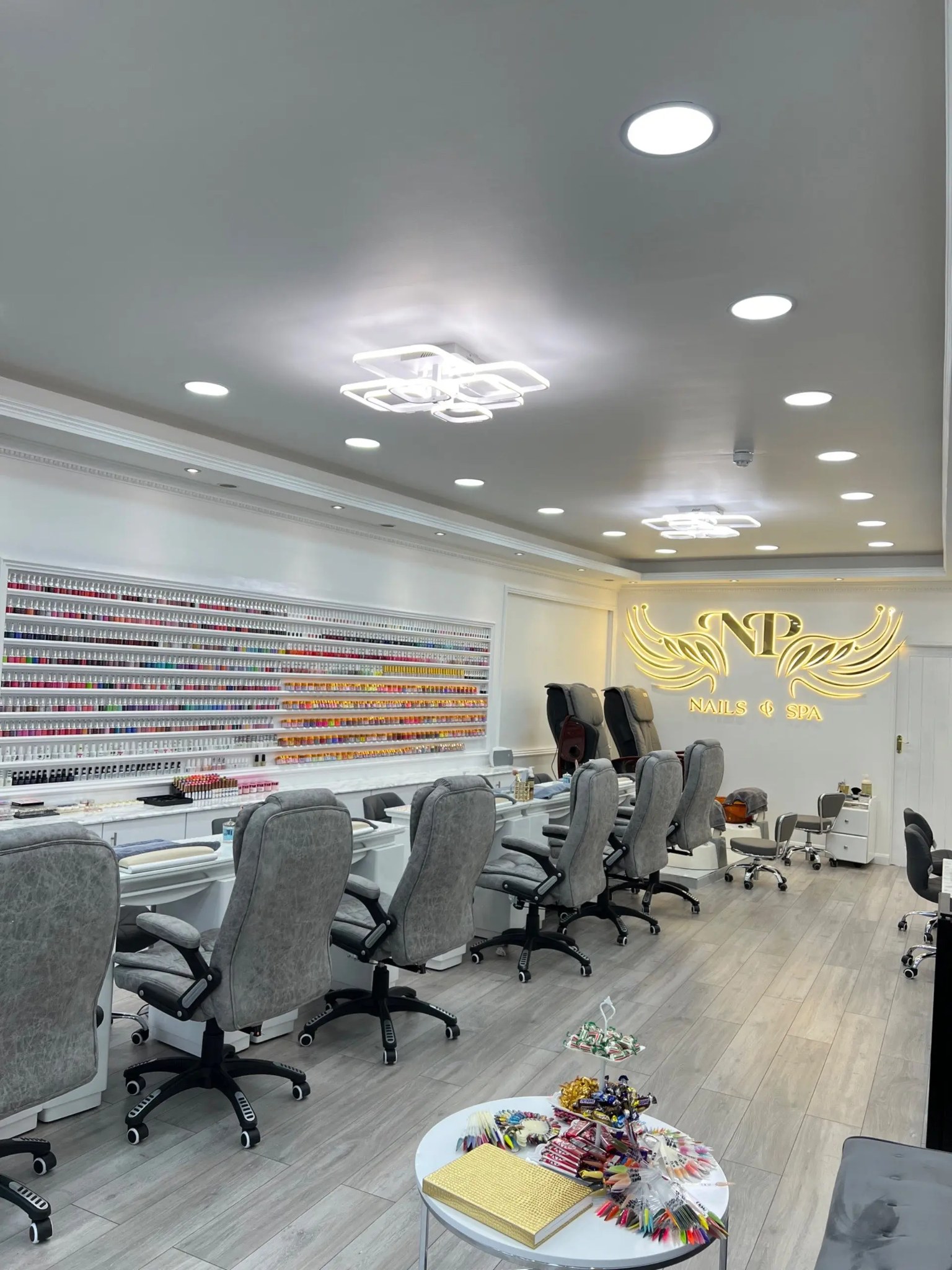 Inside NP Nails & Spa: the polish wall, manicure stations and our gold sign