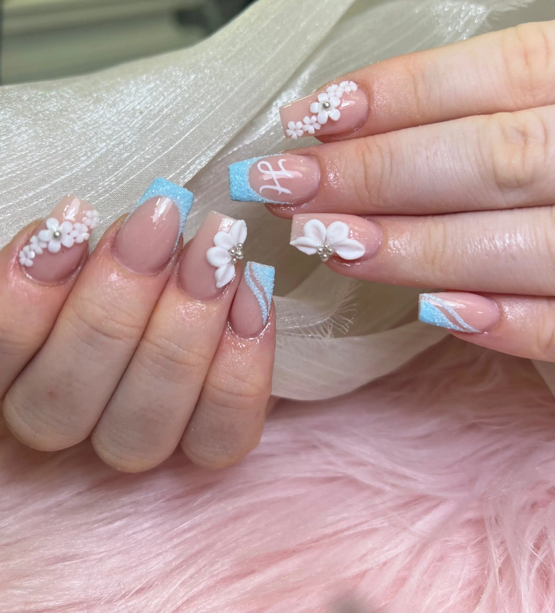 Square nails with pale blue French tips and 3D white flowers